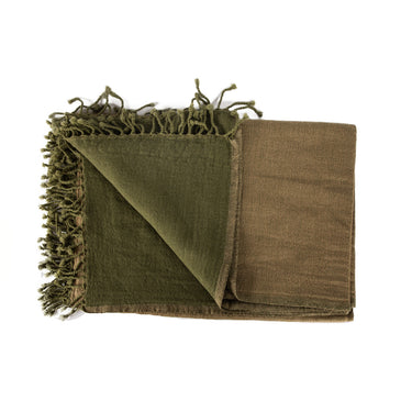 A stack of folded merino wool throws in various solid colors with fringed ends. Merino Boiled Wool Throw green brown