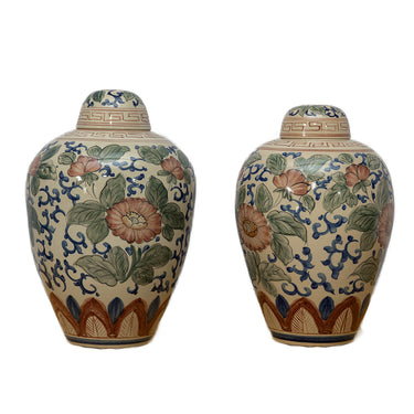 Two ceramic vases with floral and geometric patterns on a white background