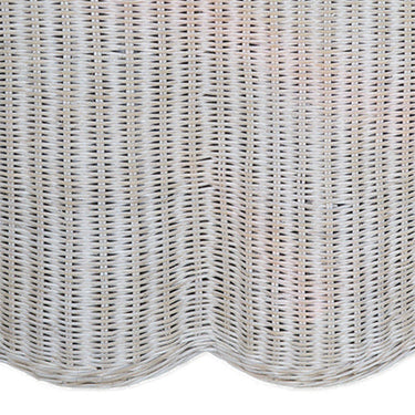 Wicker ottoman with a white cushion on a white background