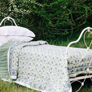 A cotton quilt with green and blue block printed design