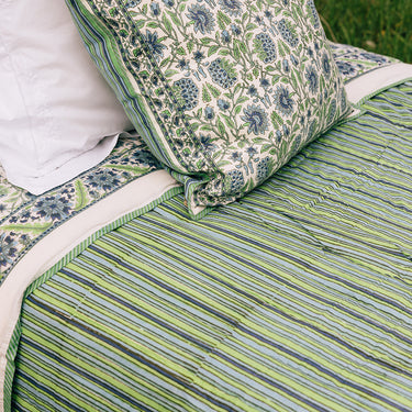 A cotton quilt with green and blue block printed design