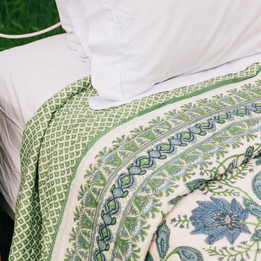 A cotton quilt with green and blue block printed design