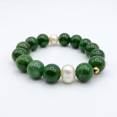 A beaded stretch bracelet featuring glossy dark green jade round beads, accented by two white freshwater pearls and a small gold spacer bead,