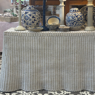 Wicker table with decorative blue and white ceramic items in a store setting