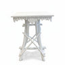 A white wooden bedside table with a scalloped apron and crossed legs