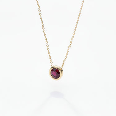 Gold necklace with a garnet gemstone pendant 