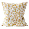 Decorative pillow with white floral pattern on a mustard yellow background